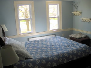 This 2nd floor bedroom has 2 windows that face east and get lovely morning light.  They look out onto a large aged sugar maple, and beyond it, the church grounds on the adjacent property.  This is a queen bed, with reading tables and lamps on both sides.